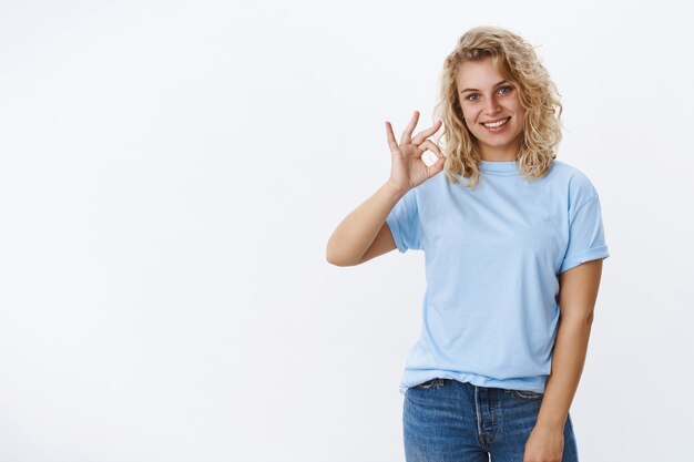 Pas de problème, d'accord. Portrait d'une jolie femme blonde joyeuse et gentille aux yeux bleus inclinant la tête et souriante ravie de montrer qu'elle va bien, excellent geste donnant des commentaires positifs sur un produit génial