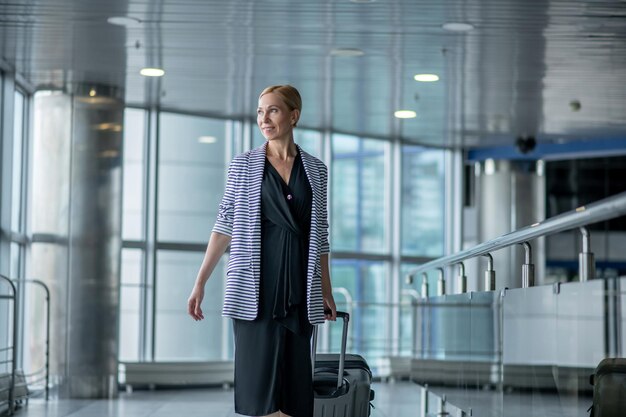 Passager de l'aéroport heureux avec ses bagages à l'écart