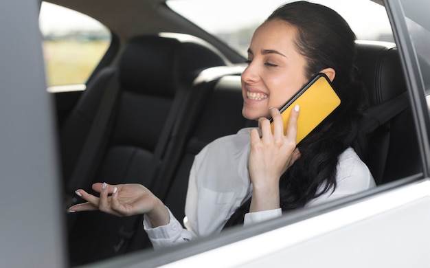 Photo gratuite passager assis dans la voiture et parler au téléphone