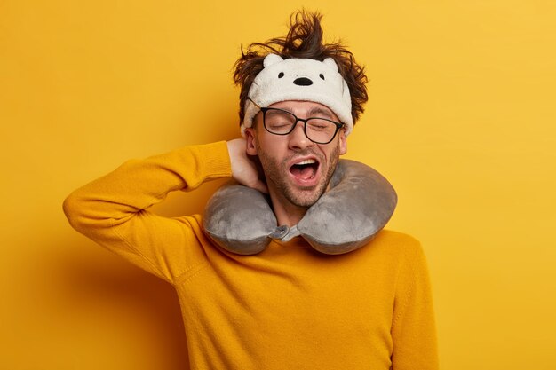 Le passager masculin porte un oreiller de voyage pour dormir pendant le voyage