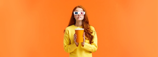 Photo gratuite passe-temps de vie et concept de personnes jolie femme rousse geek dans des verres en papier d tenant du pop-corn et b