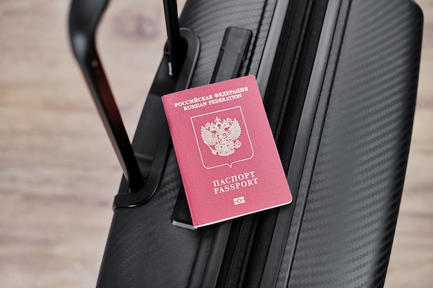 Passeport russe sur une valise de voyage noire vue de dessus arrière-plan sélectif Émigration des Russes demandeurs d'asile