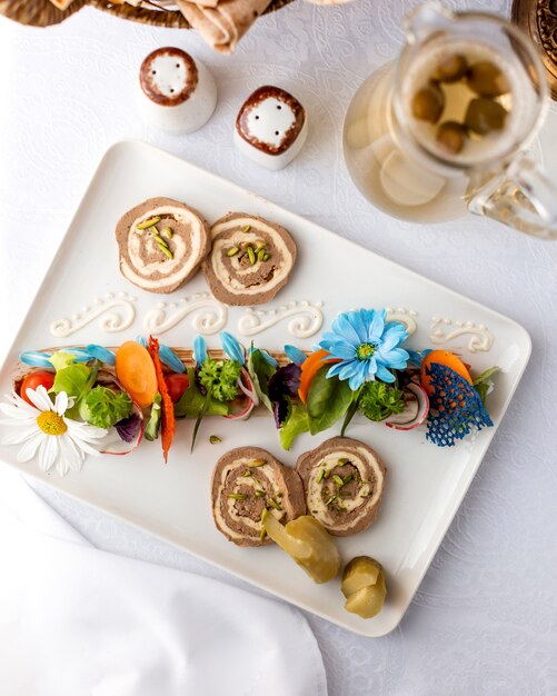 Pate décorée de concombres et de carottes et d'une cruche avec vue de dessus de compote