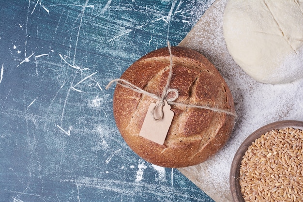 Pâte et pain cuit sur table bleue.