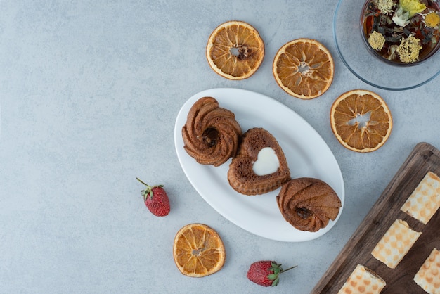 Pâte sucrée à l'orange séchée et tasse de tisane sur fond de marbre. Photo de haute qualité