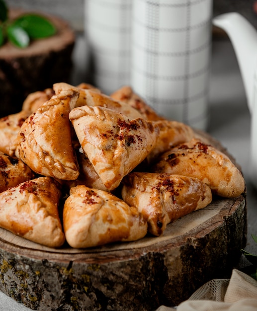 Pâte triangulaire Echpochmak fourrée d'oignon haché et de pomme de terre