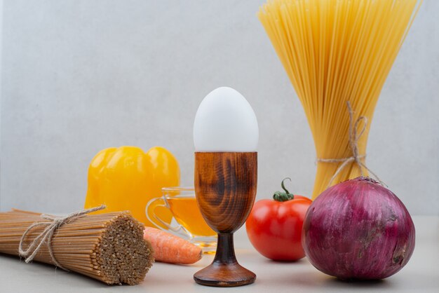 Pâtes crues aux légumes sur blanc.