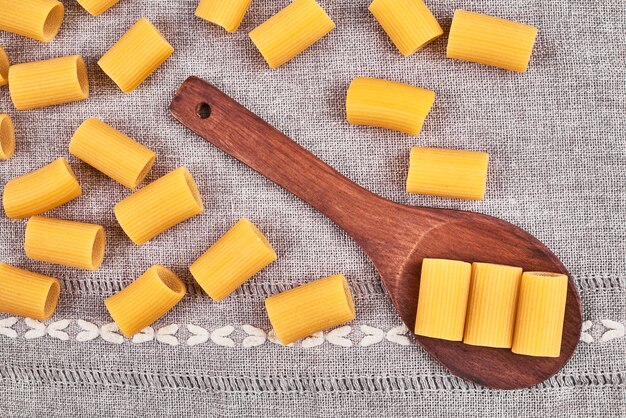 Pâtes crues dans une cuillère en bois.