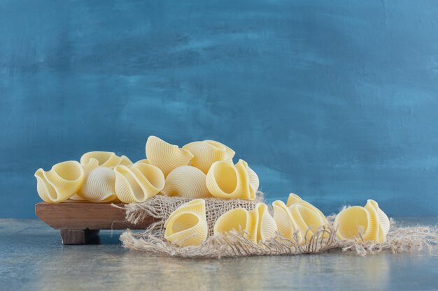 Photo gratuite pâtes crues sur dessous de plat, sur la surface en marbre.