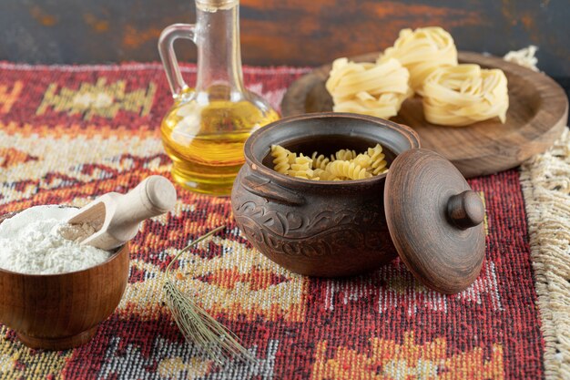 Pâtes crues en spirale en pot avec macaronis crus fettuccine