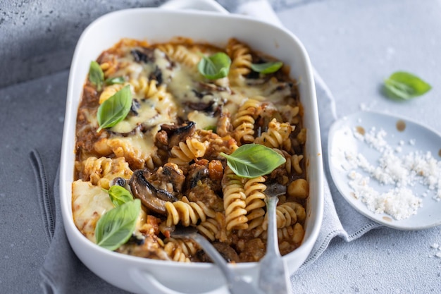 Photo gratuite pâtes cuites au four avec des légumes, de la viande et des champignons dans un bol en gros plan