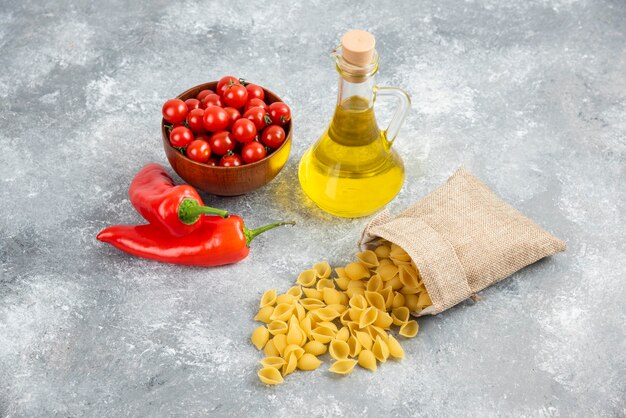 Pâtes dans des sacs rustiques servies avec des tomates cerises, des piments et de l'huile d'olive.