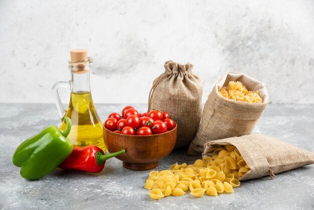 Pâtes dans des sacs rustiques servies avec des tomates cerises, des piments et de l'huile d'olive.