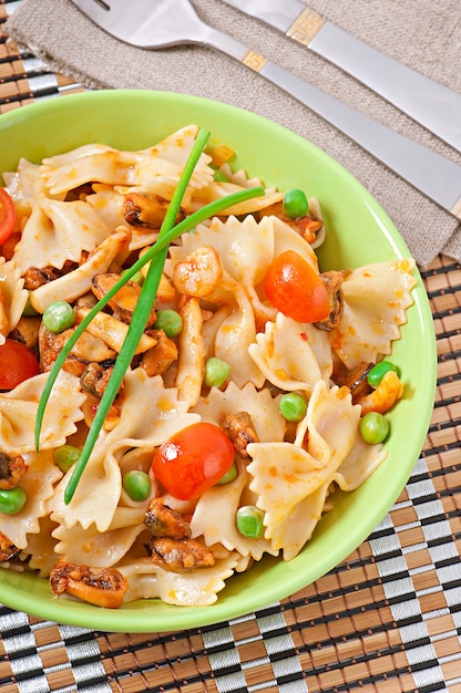 Pâtes farfalle aux fruits de mer, tomates cerises et pois verts