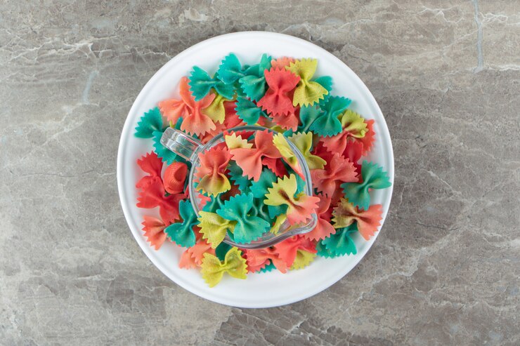 Photo gratuit pâtes farfalle colorées dans une tasse en verre.