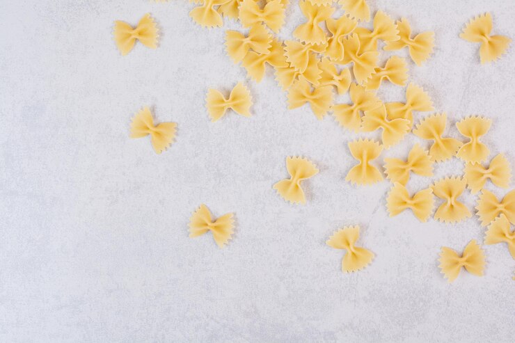 Photo gratuit pâtes farfalle crues sur tableau blanc.