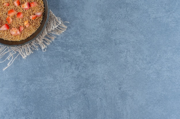 Photo gratuite pâtes frites avec des tranches de tomates sur une poêle noire.