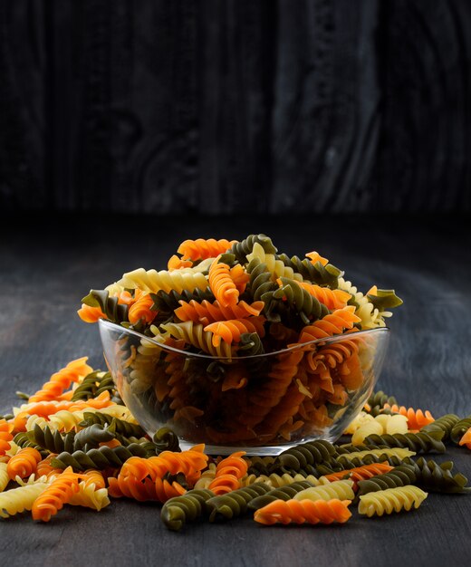 Pâtes fusilli colorées dans un bol en verre