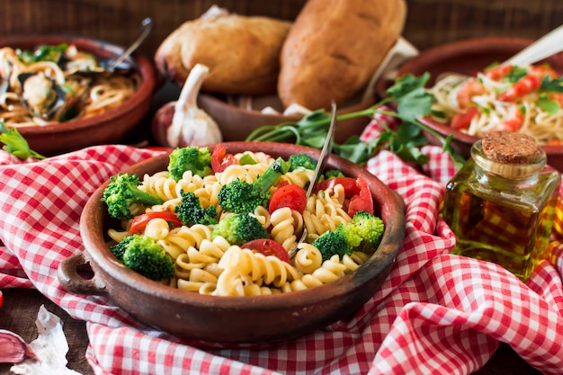 Photo gratuite pâtes fusilli végétariennes à la tomate et au brocoli dans la faïence sur nappe