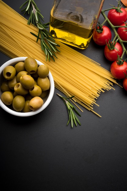 Pâtes et ingrédients pour cuisiner sur fond sombre