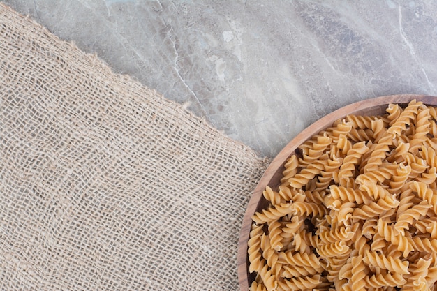 Pâtes isolées dans une plaque en bois rustique sur le marbre