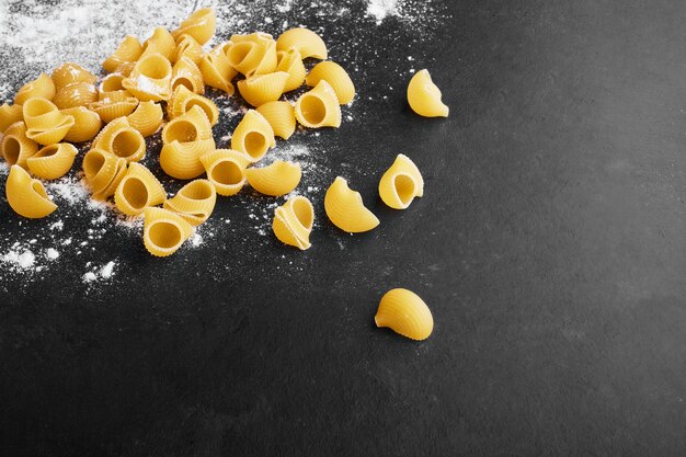 Pâtes isolées sur fond recouvert de farine.