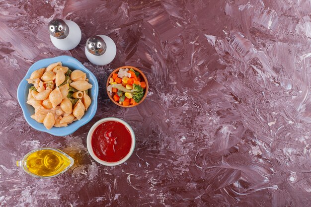 Pâtes italiennes avec sauce tomate et salade de légumes sur table lumineuse.