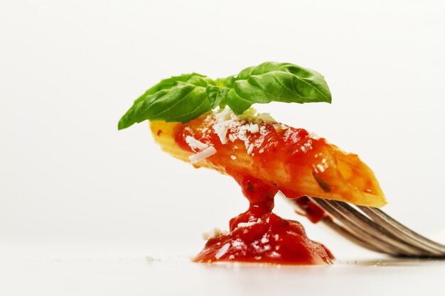 Des pâtes italiennes savoureuses et savoureuses à l&#39;apéritif et à la sauce tomate sauce basilic et framboise frais à la fourchette. Service de création, Gros plan.