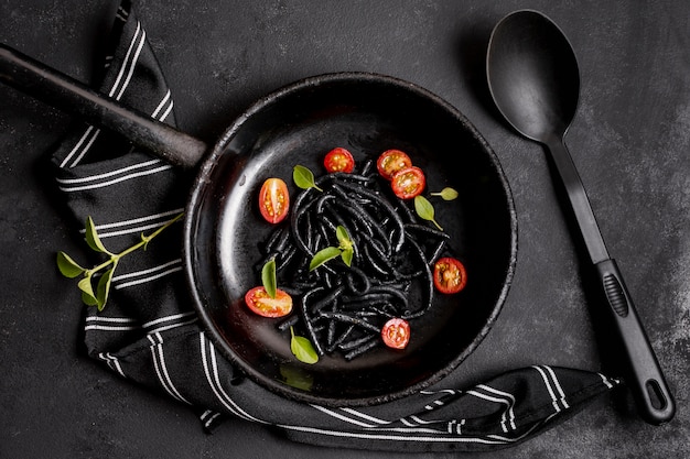 Pâtes noires aux crevettes et serviette de cuisine avec cuillère