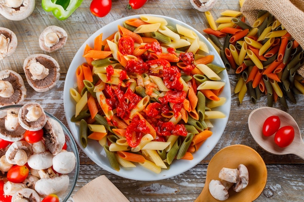 Pâtes penne dans une assiette avec sauce, tomate, champignon, poivre