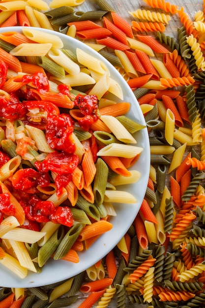 Pâtes penne à la sauce, tomate dans une assiette sur pâtes éparses