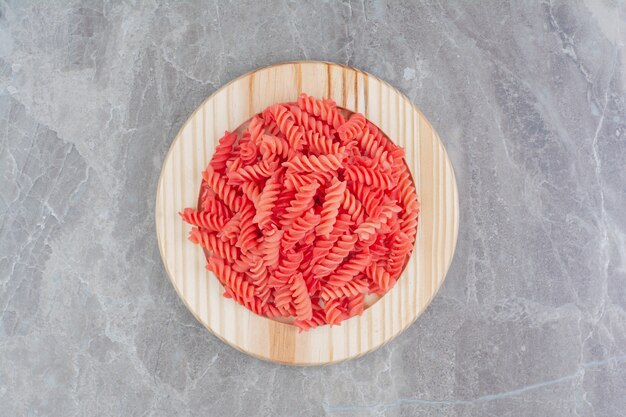 Pâtes à la sauce tomate rouge dans un plateau en bois