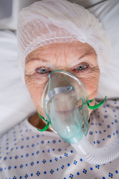 Photo gratuite patient âgé portant un masque à oxygène allongé sur un lit d'hôpital