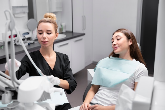 Patient et dentiste de coup moyen à la clinique