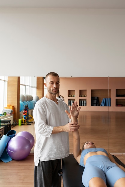 Patient Faisant De La Réadaptation Physique Aidé Par Des Thérapeutes