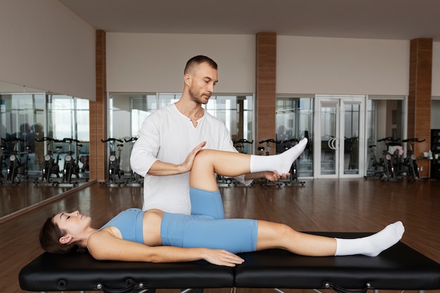 Patient faisant de la réadaptation physique aidé par des thérapeutes