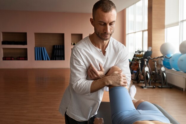 Patient faisant de la réadaptation physique aidé par des thérapeutes