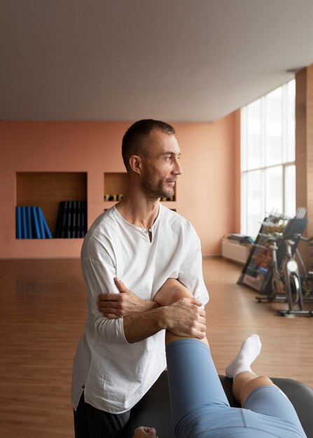 Patient faisant de la réadaptation physique aidé par des thérapeutes