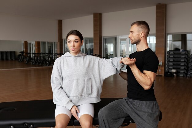 Patient faisant de la réadaptation physique aidé par des thérapeutes