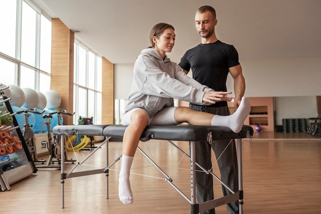 Patient faisant de la réadaptation physique aidé par des thérapeutes