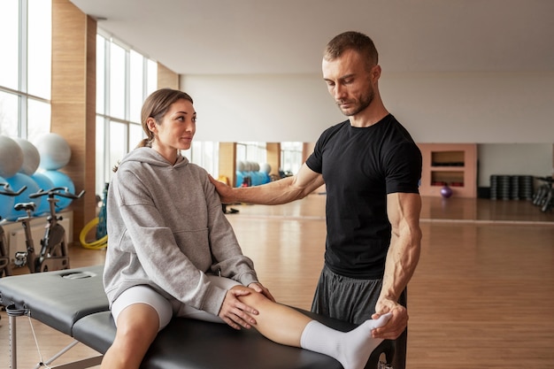 Patient faisant de la réadaptation physique aidé par des thérapeutes