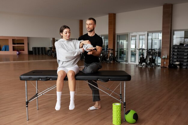 Patient faisant de la réadaptation physique aidé par des thérapeutes