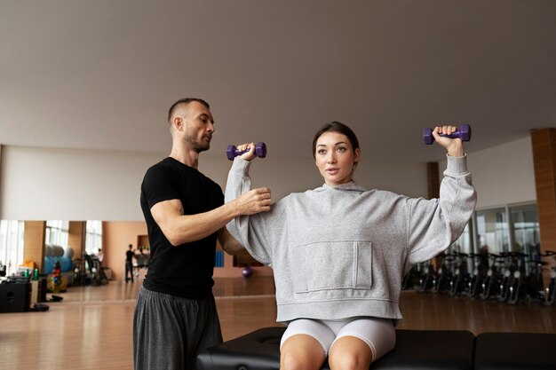 Patient faisant de la réadaptation physique aidé par des thérapeutes