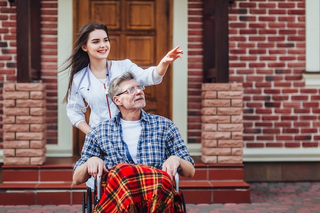 Patient senior satisfait avec un gentil médecin à la maison de retraite. Temps ensemble