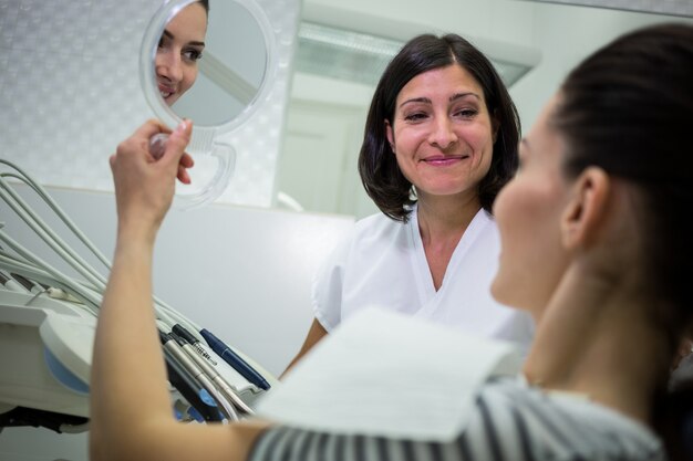 Photo gratuite patient vérifiant ses dents dans le miroir