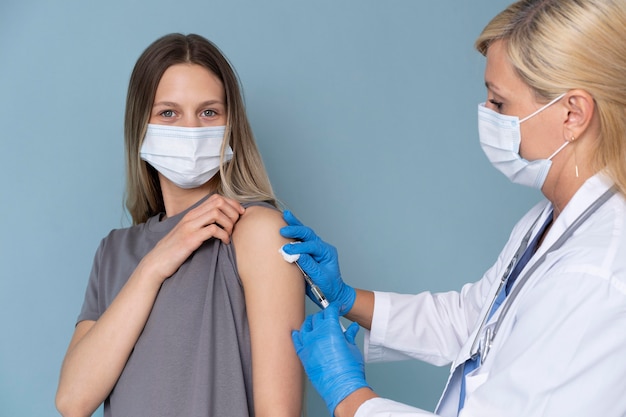 Photo gratuite patiente avec masque médical recevant un vaccin