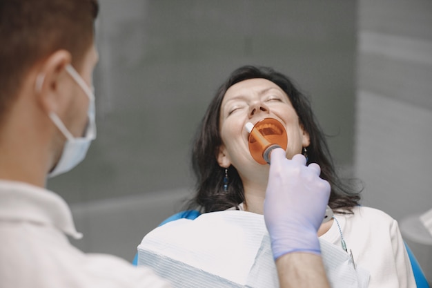 Une patiente passe un examen dentaire au cabinet du dentiste. La femme est brune