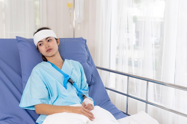 Les patients accidentés solitaires femme blessée sur le lit les patients à l'hôpital veulent rentrer à la maison - concept médical
