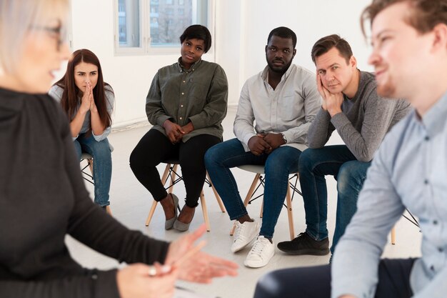 Patients en réadaptation regardant médecin parler avec un homme