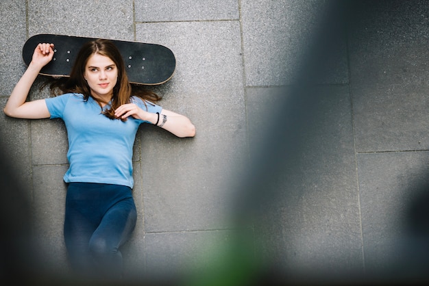 Photo gratuite patineur relaxant au sol avec skateboard